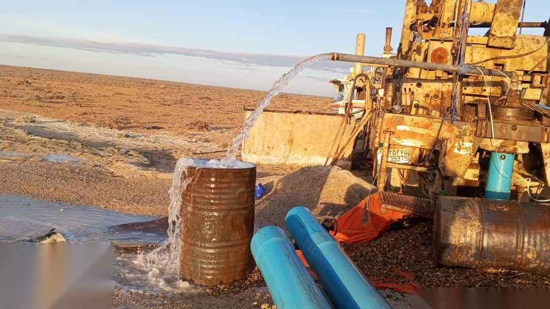 Water flowing from a newly drilled borehole at sunrise