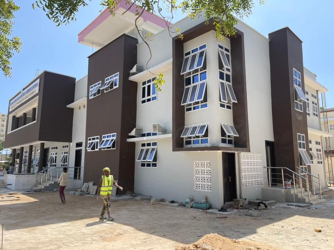 Completed multi-storey institutional building with dark brown and white facade